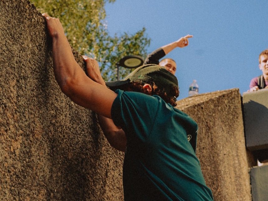 Passage d'un mur en béton pendant un entraînement de parkour en extérieur à Lyon